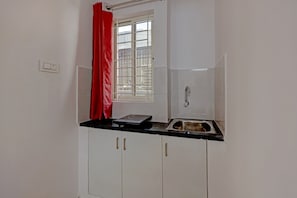 Une petite cuisine équipée d’une fenêtre, d’un évier et d’une cuisinière.