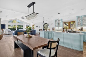 Cocina amplia con una isla grande, iluminación colgante y vistas al exterior.