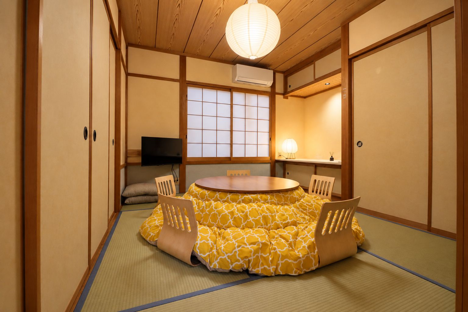 Perinteinen japanilainen huone, jossa on tatamimatto, pyöreä pöytä ja liukuovet.
