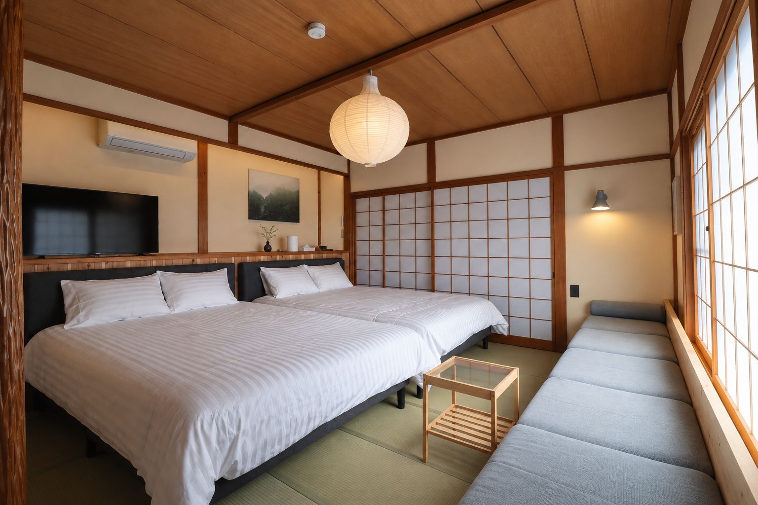 A traditional Japanese-style room with tatami flooring, a low wooden ceiling, and sliding shoji doors.