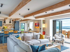 A modern living space with a sofa, coffee table, and dining area. - Fairlie Ward Cottage (Fairlie)