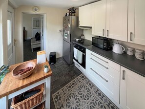 A modern kitchen with white cabinets, a black countertop, and a microwave. - 2 bedroom accommodation in Fir Tree, near Bishop Auckland (Fir Tree, near Bishop Auckland)