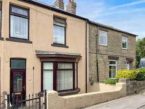 A two-story residential building with a bay window on the ground floor, a stone facade, and a clear sky. - 2 bedroom accommodation in Fir Tree, near Bishop Auckland (Fir Tree, near Bishop Auckland)