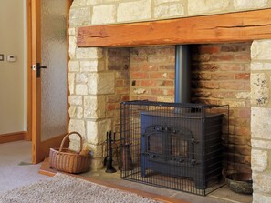 A stone fireplace with a metal stove, a basket, and a dog bowl. - 4 bedroom accommodation in Coaley (Coaley)