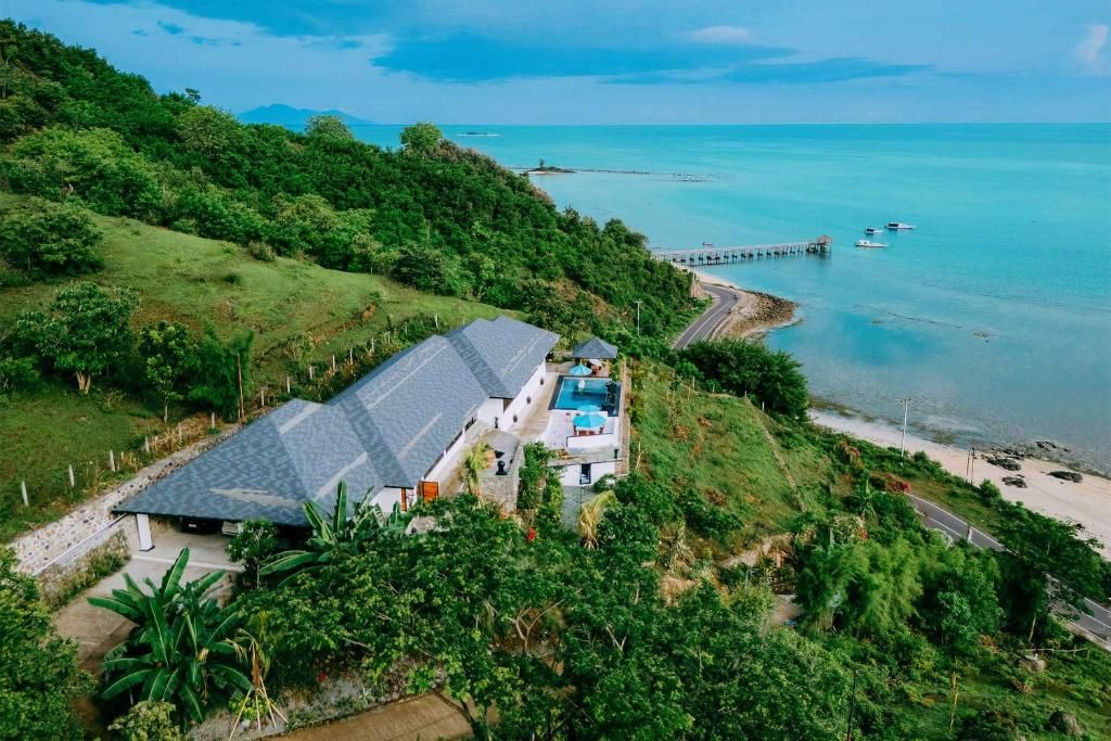 Une propriété située sur la côte, dotée d’une piscine, d’un quai et offrant une vue sur la mer.