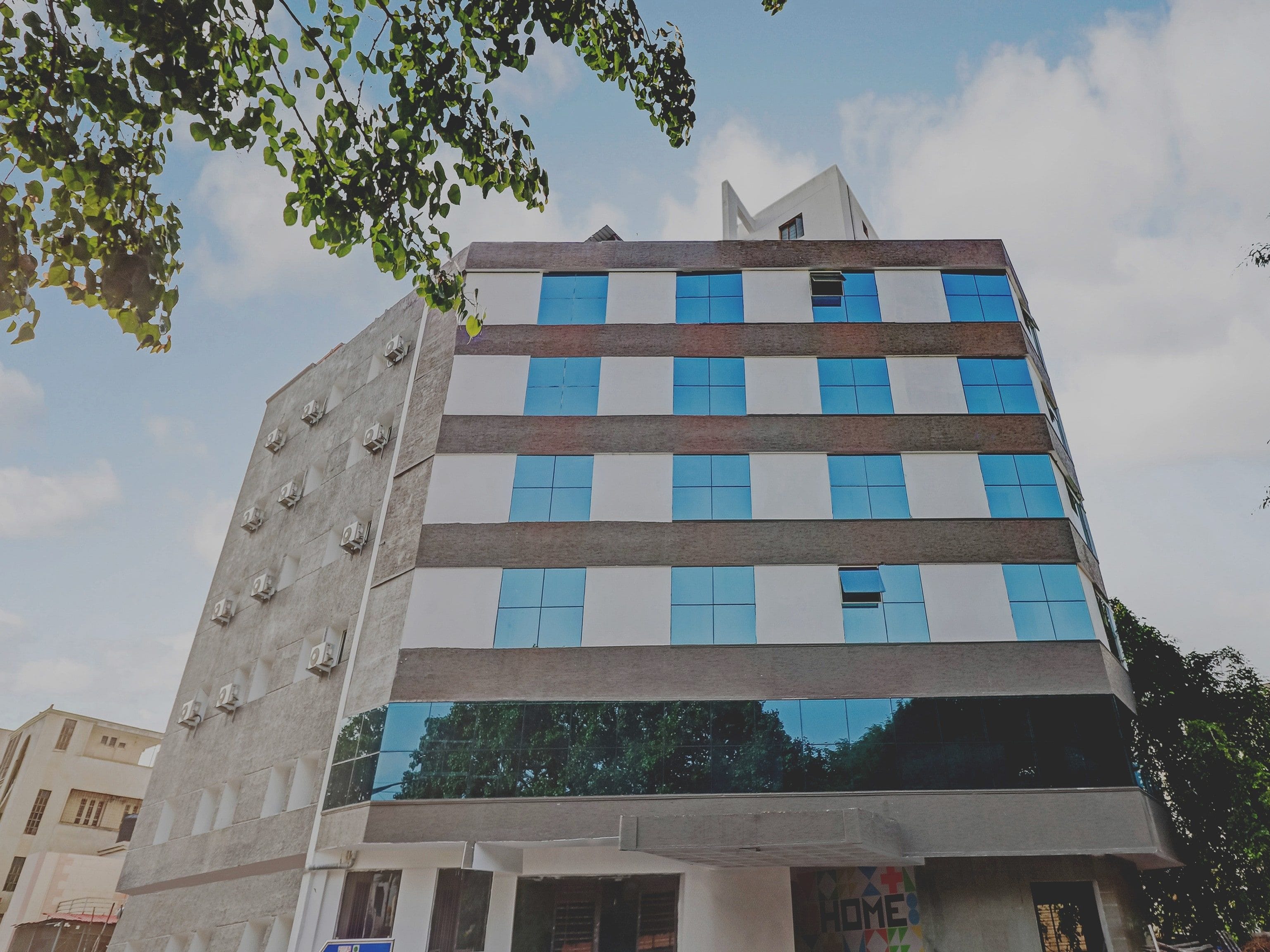 A multi-story building with a modern architectural design, featuring a mix of glass and concrete facades, and a visible storefront at the ground level.