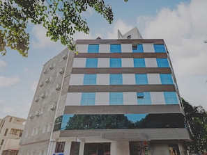 A multi-story building with a modern architectural design, featuring a mix of glass and concrete facades, and a visible storefront at the ground level. - Capital O Elite Stay Jp Nagar  (Bangalore)