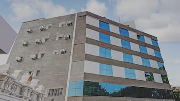 Un edificio de varios pisos con un diseño arquitectónico moderno, que combina fachadas de vidrio y hormigón.