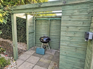 A wooden outdoor barbecue area with a grill and a blue cooler. - 2 bedroom accommodation in Bodham, near Sheringham (Bodham, near Sheringham)