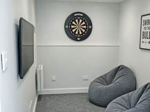 A room with a dartboard, a flat-screen TV, and two bean bags. - 2 bedroom accommodation in Bodham, near Sheringham (Bodham, near Sheringham)