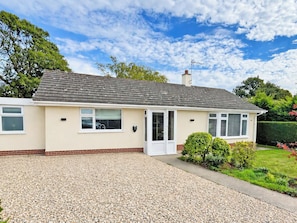 A single-story house with a tiled roof, a gravel driveway, and a well-maintained garden. - 2 bedroom accommodation in Bodham, near Sheringham (Bodham, near Sheringham)