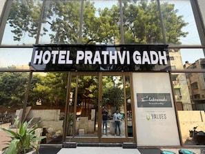 L'entrada de l'Hotel Prathvi Gadh, amb una vista clara de l'interior a través de les portes de vidre.