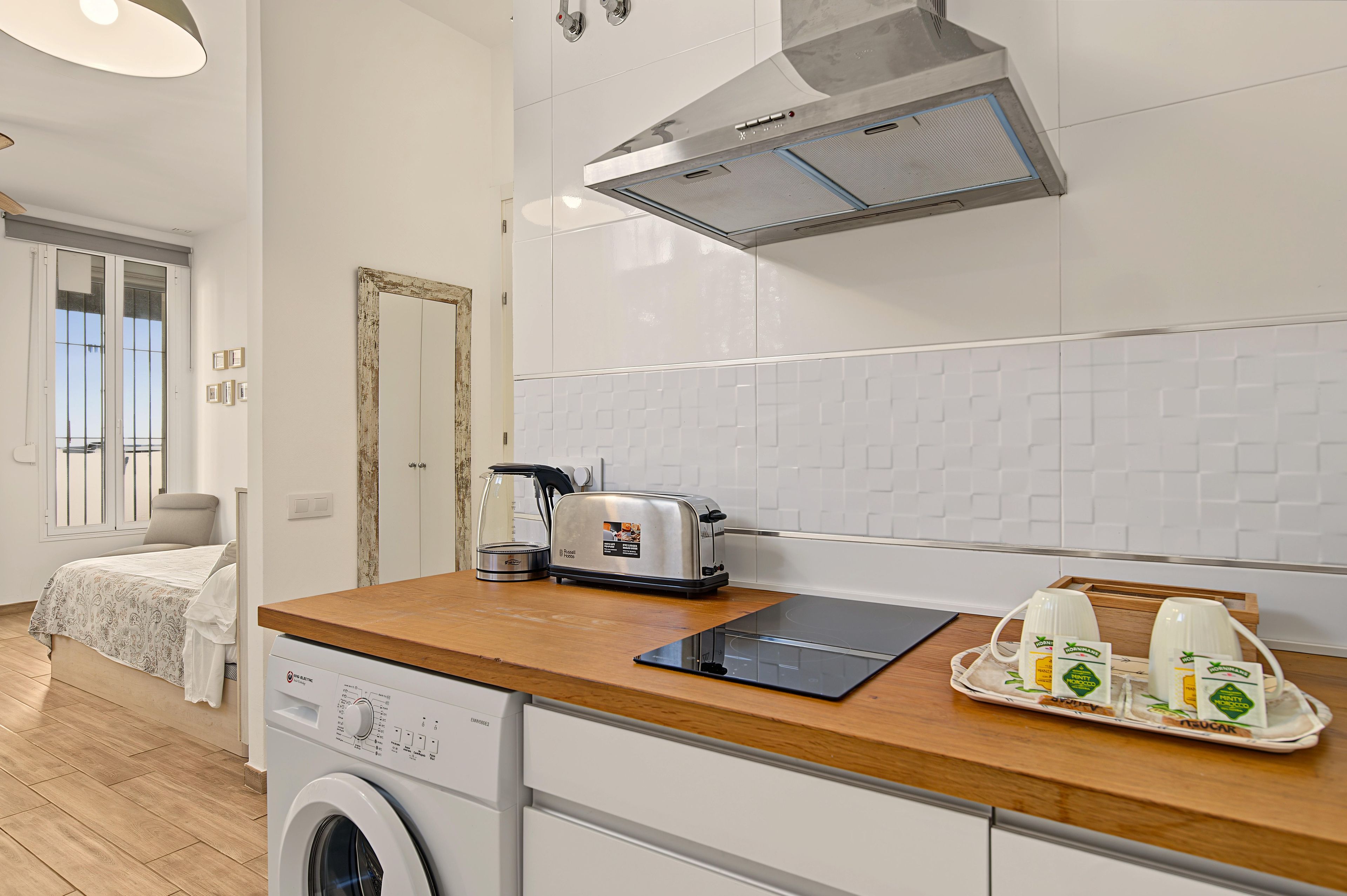 Una cocina moderna con lavadora, tostadora y una bandeja de cartones de leche.