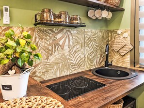 A kitchen with a modern design, featuring a black sink, a built-in stove, and a decorative backsplash. - Le fonti by Interhome (Foiano della Chiana)