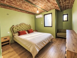 A bedroom with a bed, a wooden nightstand, a bench, and a window. - Le fonti by Interhome (Foiano della Chiana)