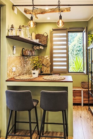 A kitchen with a wooden ceiling, a window with blinds, and two bar stools. - Le fonti by Interhome (Foiano della Chiana)