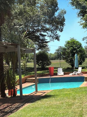 A backyard with a swimming pool, a pergola, and a fenced area. - Charming B&B Retreat in Springs with Private Room and Shared Pool (Springs)