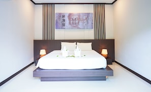 Une chambre moderne avec un grand lit, deux tables de chevet avec des lampes, une œuvre d’art accrochée au mur et une tête de lit en bois.