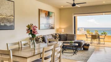 Un espacio habitable amplio con una mesa de comedor, sofá y un balcón con vistas al océano.