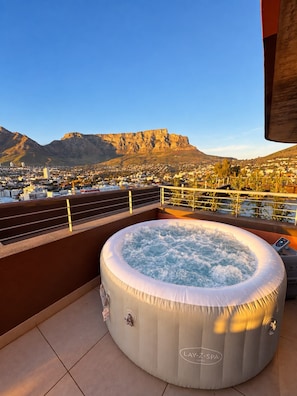 A hot tub on a balcony with a cityscape and mountains in the background. - The Outlook - Luxury Living Above Cape Town (Cape Town)