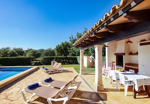A poolside area with lounge chairs and a barbecue setup. - Villa 'Juanito' with Private Pool, Wi-Fi and Air Conditioning (Illes Balears)