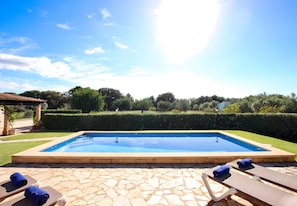 A swimming pool with lounge chairs and a stone patio. - Villa 'Juanito' with Private Pool, Wi-Fi and Air Conditioning (Illes Balears)