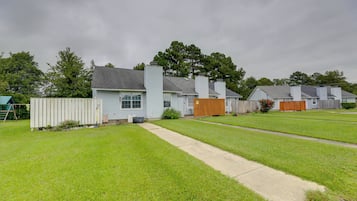 A residential area with houses, a grassy yard, and a wooden fence.