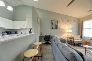 A modern living space with a kitchen, a dining area, and a seating area with a sofa and chairs. - Havelock Stay Near MCAS Cherry Point & Coast (Havelock)