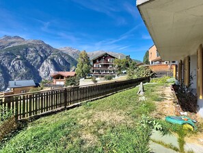 Bergblick mit einem Holzhaus und einem modernen Gebäude mit Balkon.