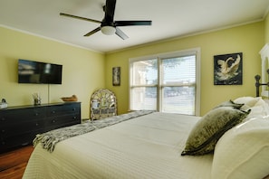A bedroom with a bed, a dresser, a television, a ceiling fan, and a window with blinds. - Adorable 1930s Cottage: Downtown + Dog Friendly (Granbury)