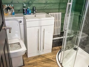 Un baño con inodoro, lavamanos y cabina de ducha.