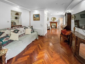 Un salon avec un canapé, un téléviseur et une cheminée.