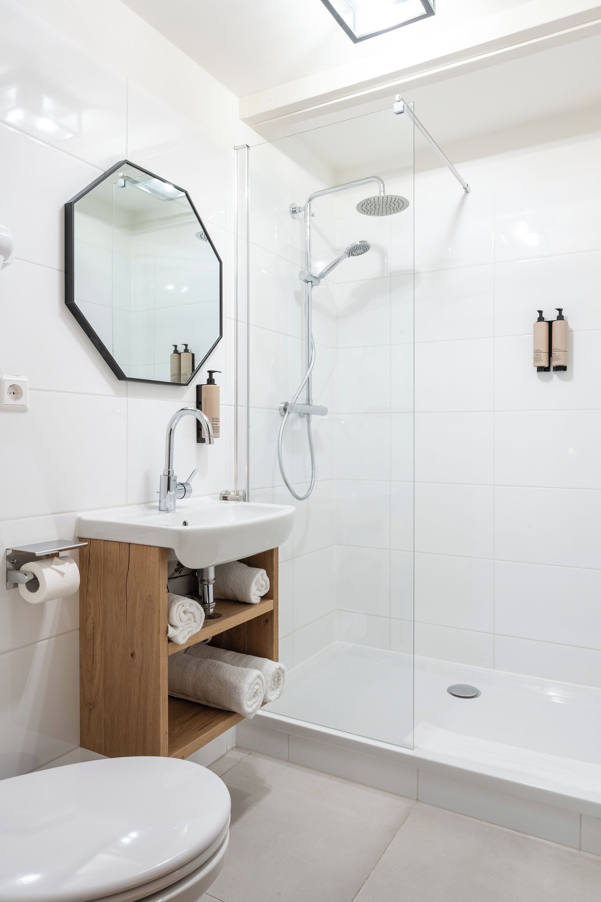 Un bagno moderno con WC, lavandino, doccia e cabina doccia in vetro.
