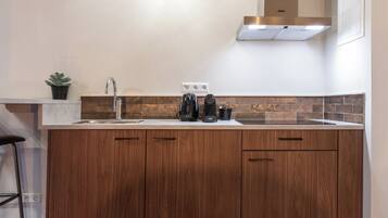 Een keuken met een houten keukeneiland, roestvrijstalen apparatuur en een betegelde achterwand.
