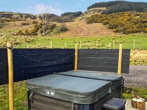 A portable outdoor cooking station with a built-in grill, surrounded by a wooden fence, set against a rural landscape with hills and a fenced field. - 1 bedroom accommodation in Lerags (Lerags)