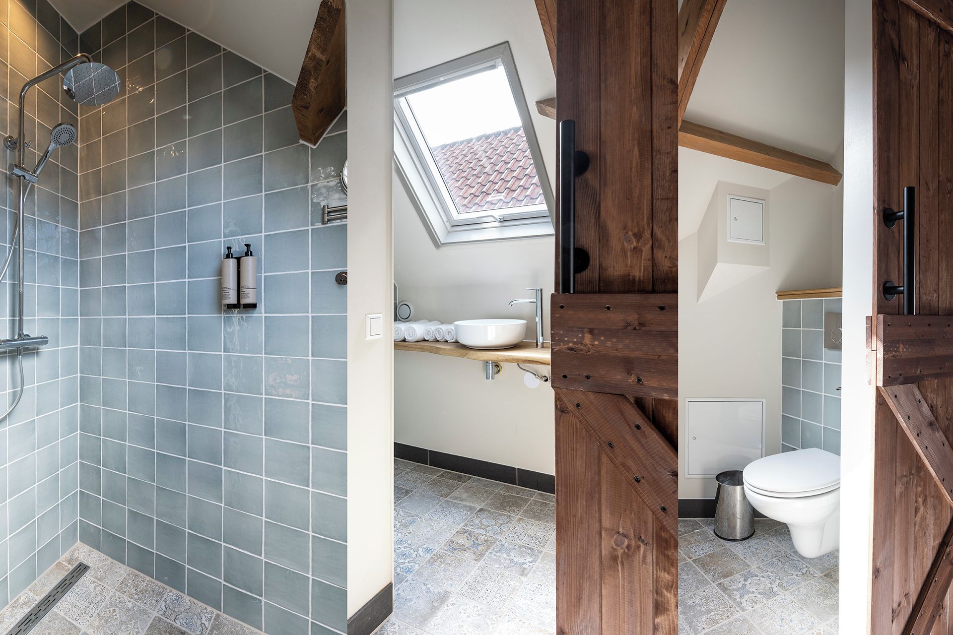 A bathroom with a shower, a skylight, a sink, and a toilet.