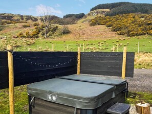 A portable camping stove with a lid, placed on a gravel surface, surrounded by a wooden fence and a grassy field with a fence in the background. - 1 bedroom accommodation in Lerags (Lerags)