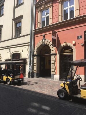 A building with a red facade, a black gate, and a sign with the number 4. - Kings City Sławkowska Apartments (Kraków)