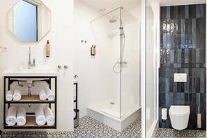 Un bagno con un lavandino bianco, una cabina doccia in vetro e un water.