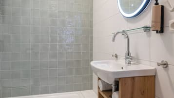 Ein modernes Badezimmer mit Badewanne, Waschbecken, Spiegel und Dusche.