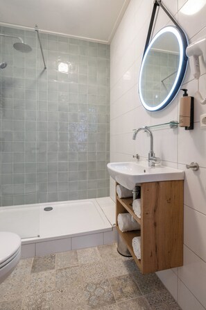 Un bagno moderno con una vasca, un lavandino, uno specchio e una doccia.