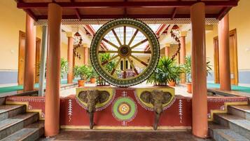 A traditional architectural structure with a large wheel, columns, and steps leading to a platform.