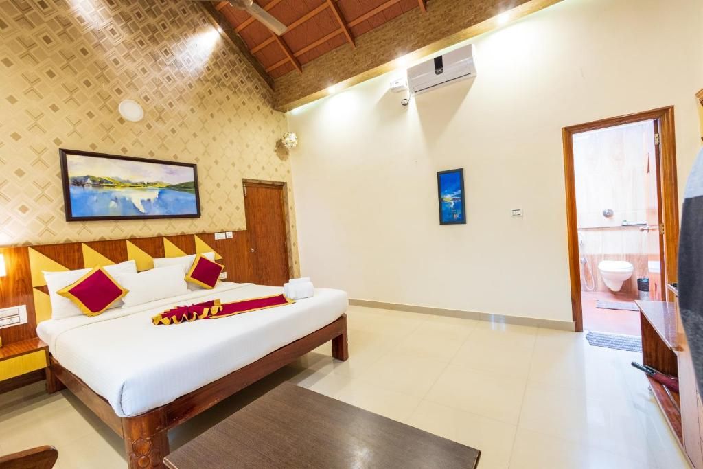 Una camera d'albergo con un letto, un quadro, una porta e vista sull'esterno.