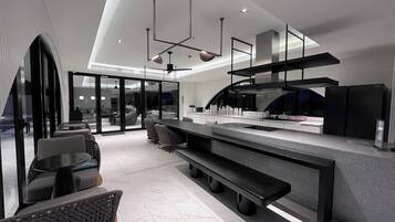 A modern kitchen with a large island, built-in appliances, and a seating area with chairs and a sofa.