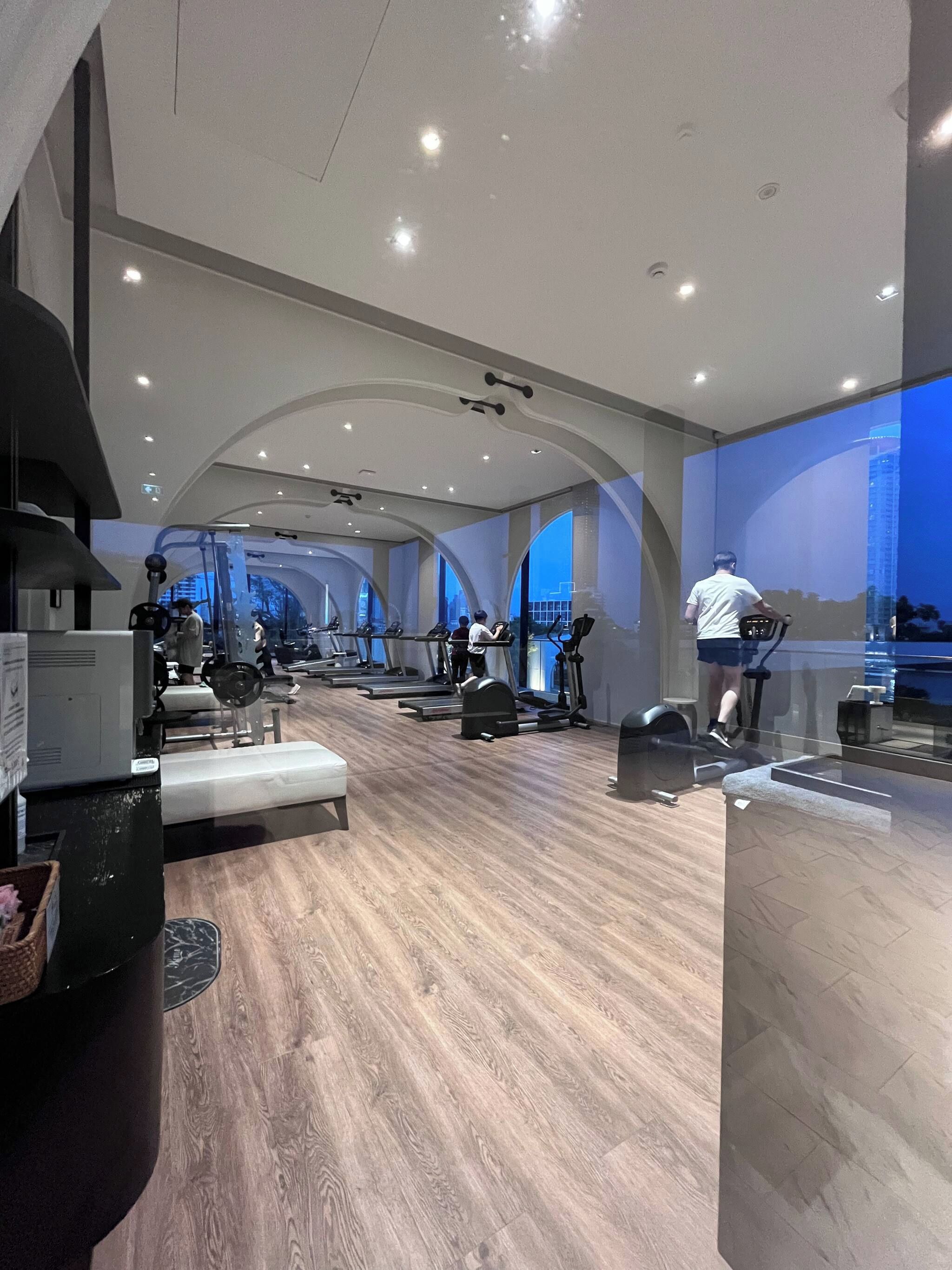 A modern gym with multiple treadmills, stationary bikes, and weight machines.