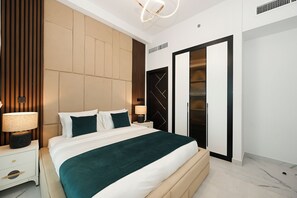 A modern bedroom with a large bed, bedside tables, a wardrobe, and a ceiling light fixture. - Bloomfields 1BR in Opalz by Danube (Dubai)