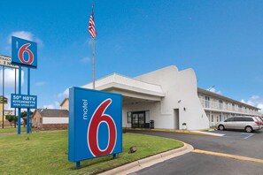 A motel with a large '6' sign, an American flag, and a sign indicating 50' HDTV and high-speed WiFi. - Comfy 2 Queen Beds | Nsmk, Micfridge (Remote City USA)