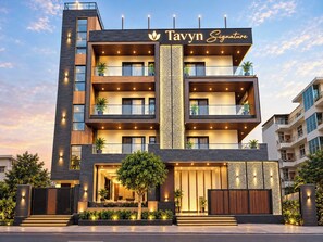 A multi-story building with a modern design, featuring balconies, a prominent entrance, and a sign that reads 'Tavyn Signature'. - Tavyn Signature - Noida Sector 117 (Noida)