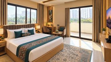 Quarto de hotel com uma cama grande, uma mesa, uma cadeira e uma televisão.