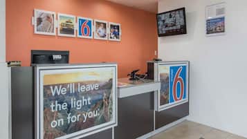 A reception desk with a large sign stating 'We'll leave the light on for you.'